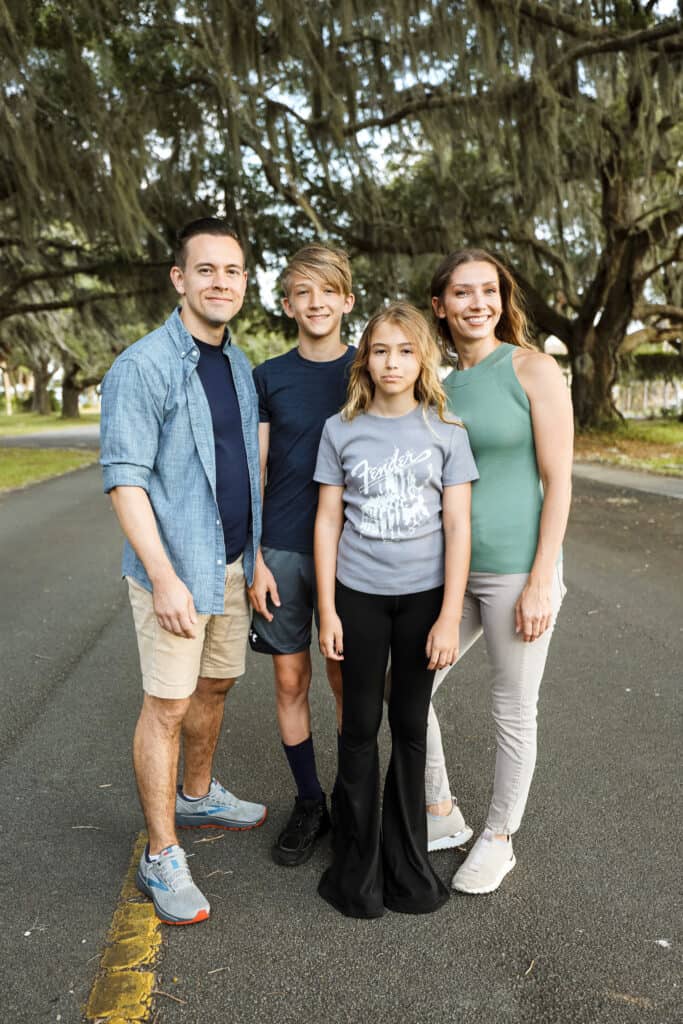 a family posing for a picture in the street covered by Parris Island trees and spanish moss