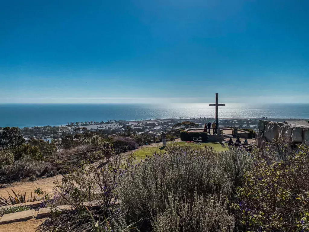 Sierra Cross at Grant Park, perched atop a hillside with views of the town below and the ocean, its waters shimmering under the sun's radiant glare.