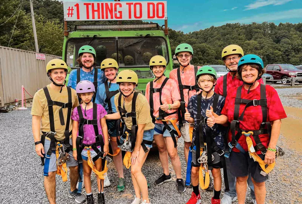 A family dressed in coordinating t-shirt colors huddles for a group photo before setting off for a zip lining adventure in Tennessee.