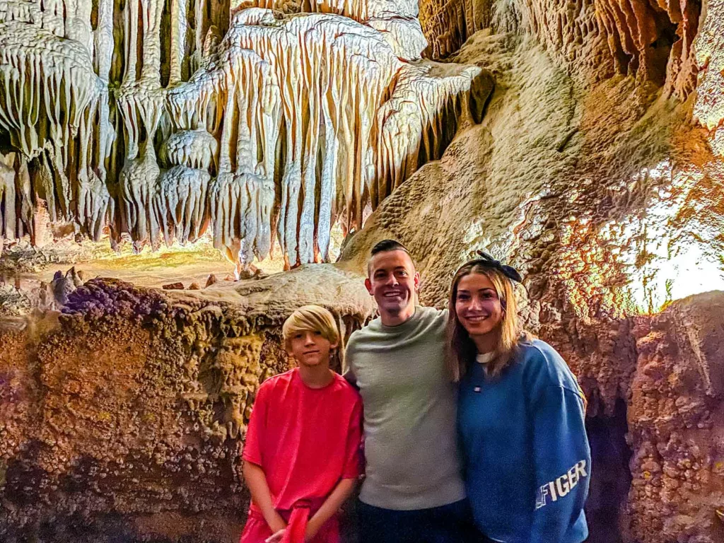 family smiling in front of intricate stalactites during a Tennessee vacation to Bristol Caverns