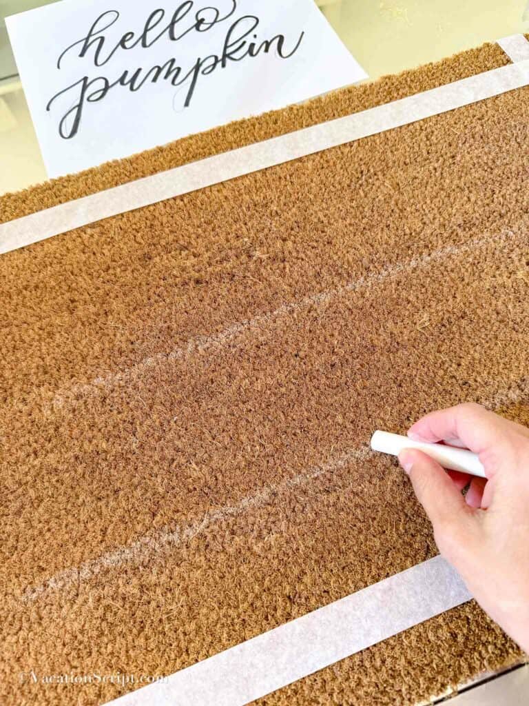 chalk line drawn to help guide lettering on doormat