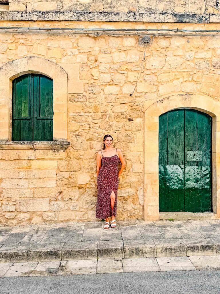 green front door and window against orange brown wall in Ragusa, Sicily
