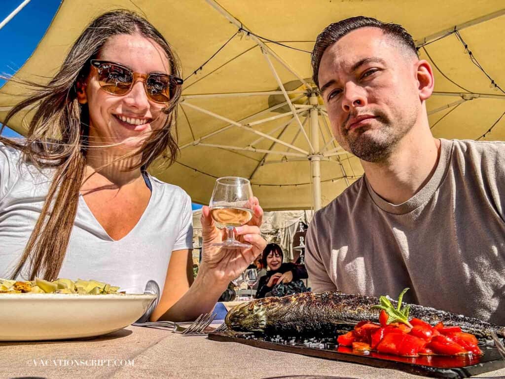 Couple enjoying a meal at a waterfront restaurant in Marzamemi, Sicily