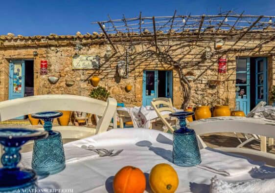 Marzamemi piazza at sunset with golden light and outdoor cafés in Sicily