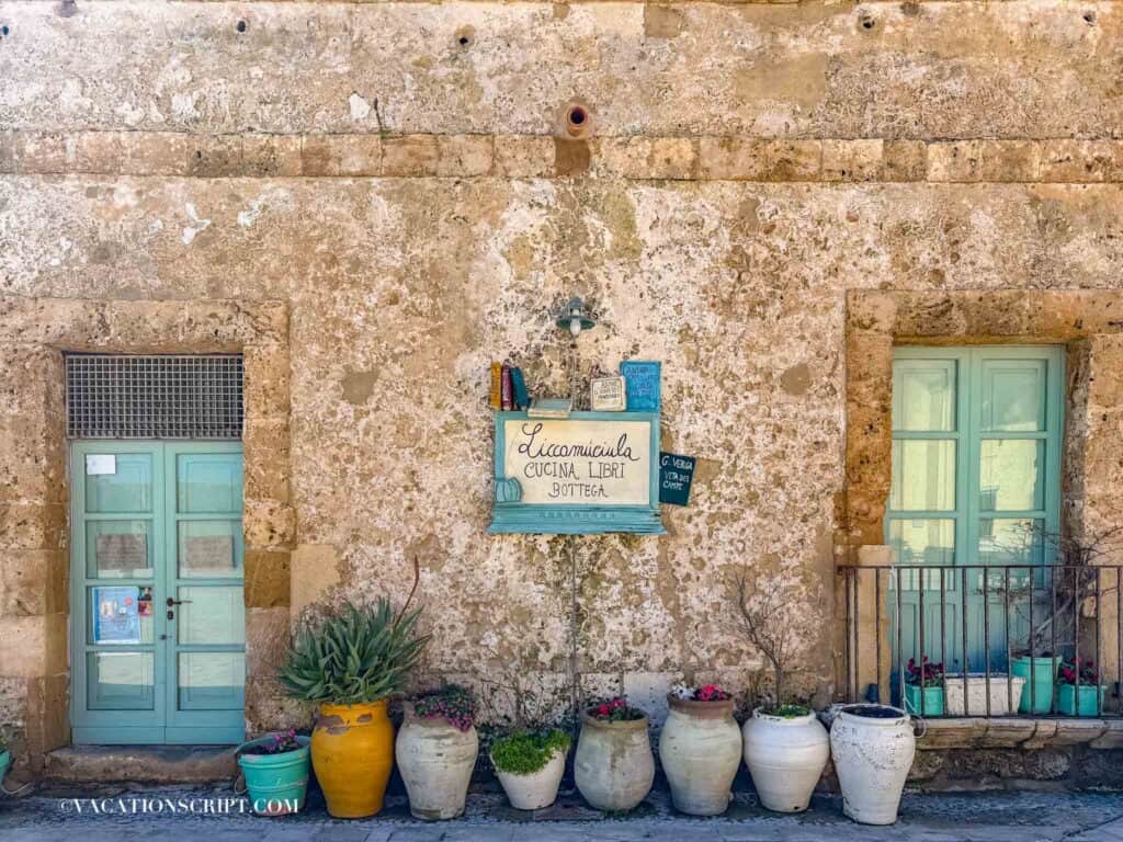 Colorful Sicilian bottega with painted ceramic pots and bold doors in the main square of Marzamemi