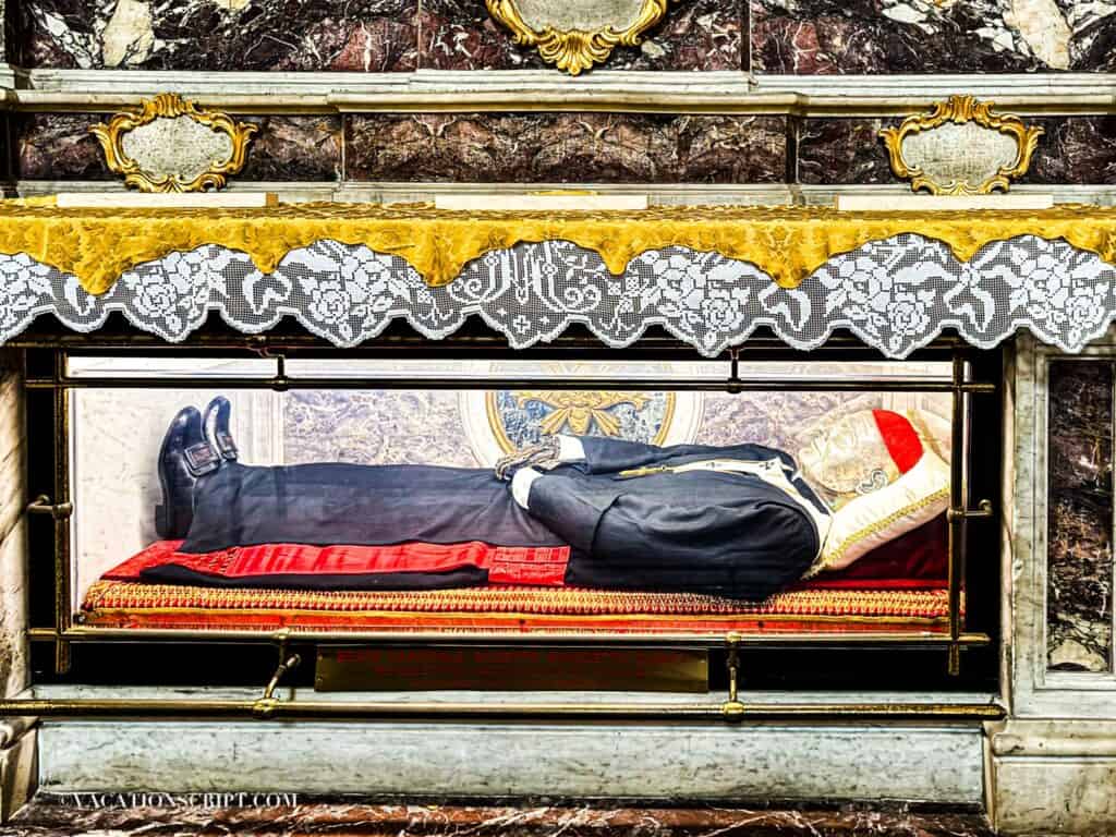 Interior view of Catania’s Cathedral of Sant’Agata showing the partially covered body of composer Vincenzo Bellini, with his hands visibly showing signs of deterioration.